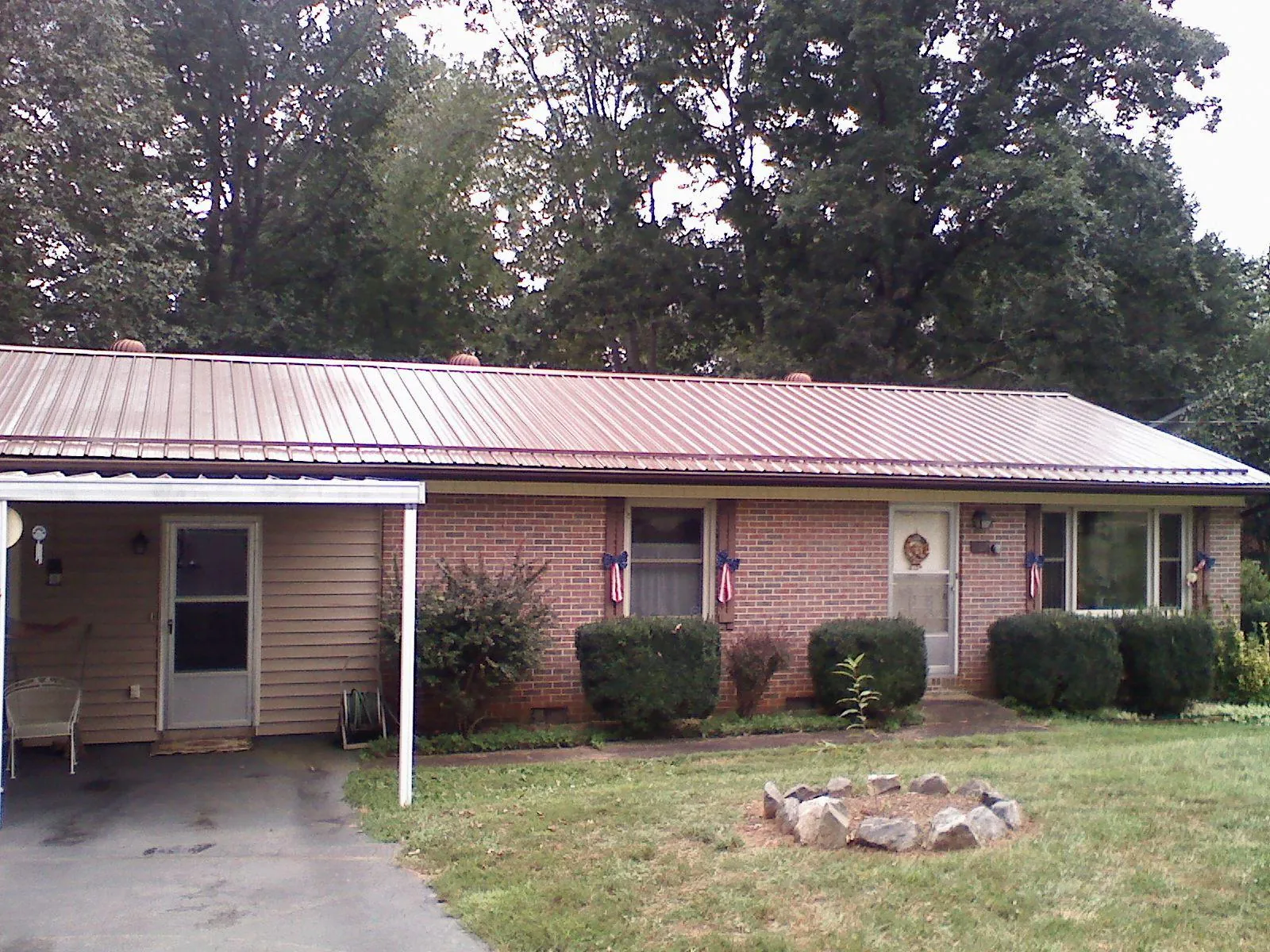 Bronze metal roof and carport on a brick ranch home — Roof Repair work by our crew in Days Creek